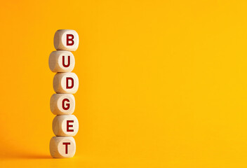 The word budget on wooden cubes against yellow background. Financial budget or investment increase or growth in business concept.