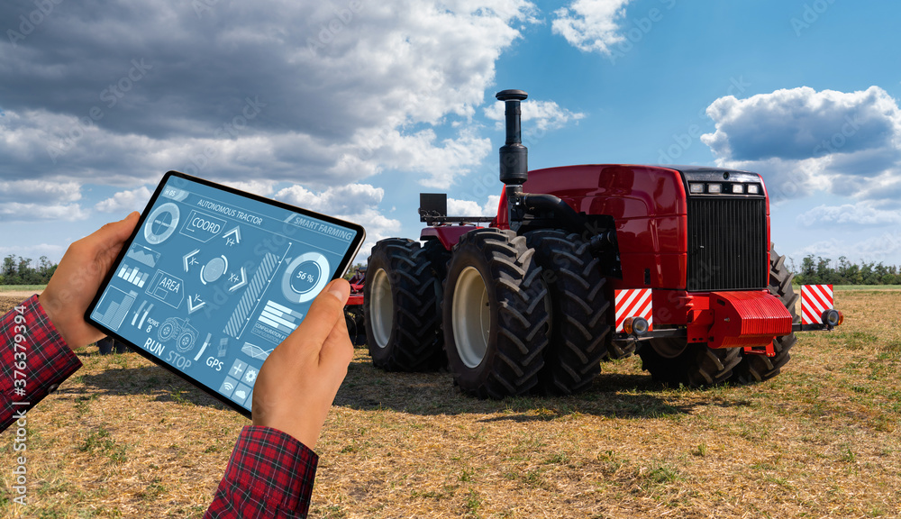 Poster a farmer with digital tablet controls an autonomous tractor on a smart farm