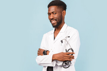 medicine, profession and healthcare concept. African american male doctor with stethoscope in white coat on blue background