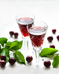 Cherry liqueur in a glass and fresh fruits
