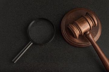 Gavel with magnifying glass on black background. Forensic investigation. Collection of evidence....
