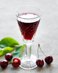Cherry liqueur in a glass and fresh fruits