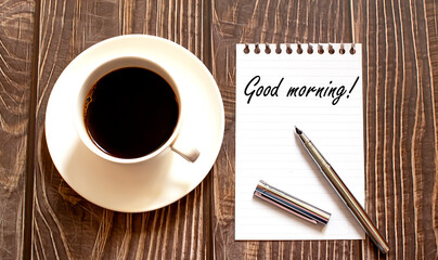 GOOD MORNING - white paper with pen and coffee on wooden background