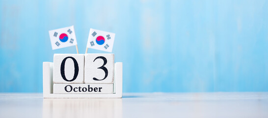 Wooden calendar of October 3rd with miniature  Republic of Korea flags. National Foundation Day, Gaecheonjeol, public Nation holiday Day and happy celebration concepts