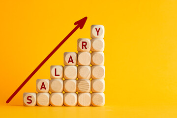 Salary raise or wage increase concept. The word salary on stacked wooden blocks with an ascending...