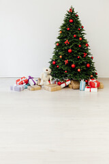 The interior of the white room is a green Christmas tree with red gifts for the new year decor winter holiday