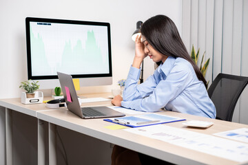 Working Asian women feel stressed, tired from work, migraine headaches from hard work while working at the office