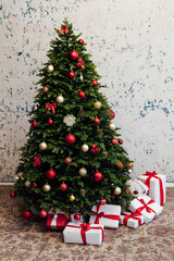 The interior of the white room is a green Christmas tree with red gifts for the new year holiday decor