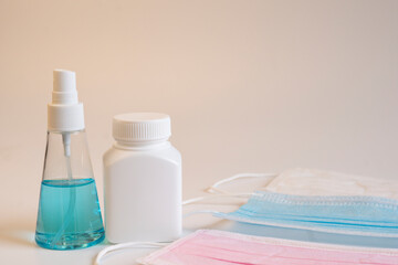 Alcohol spray and white plastic medicine bottle with masks of various on white backgound. Healthcare and medical concept.