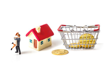 miniature couple with tiny home and piggy bank isolated on white background.