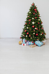 The interior of the room is a green Christmas tree with red gifts for the new year decor of the winter holiday home