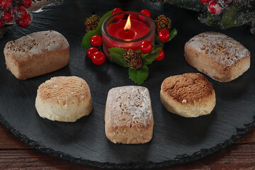 polvorones and lighted decorative red candle on round slate plate.