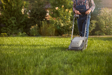 Gardener taking care of his lawn using a grass cutter