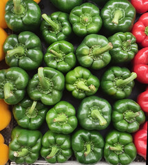 stack of fresh green bell pepper in supermarket.