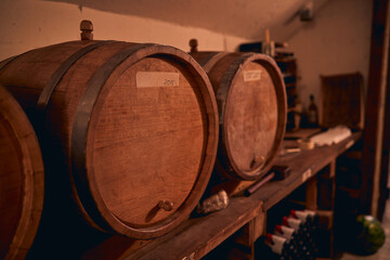Traditional oak barrels with wine in storage room