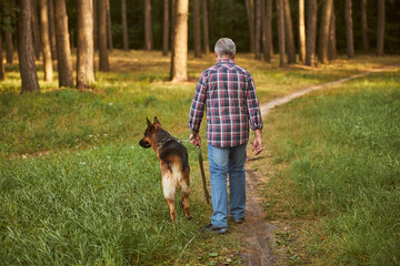 Senior citizen having a walk with his dog