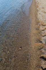 High tide on a sandy beach. Footprints in the sand