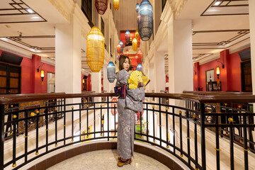 Young woman in traditional Japanese kimono is standing and looking at camera, Japanese concept of...
