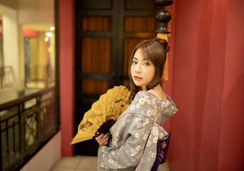 Young woman in traditional Japanese kimono and looking at camera, Japanese concept of kimono and...