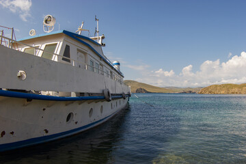 Fototapeta na wymiar Old boat near the shore against the background of Lake Baikal