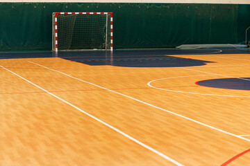 Gym for playing futsal, mini-football. Folded wooden parquet on the field of hall for mini-football. Futsal ball and bright line markings on the floor. Floor sports hall with bright lines of marking - 376389773