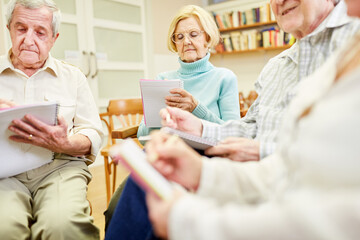 Seniors group with writing pad or drawing pad