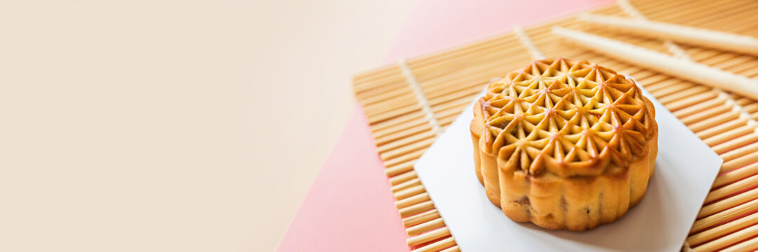 Flat lay of Chinese Festival dessert, Mid Autumn Festival Moon cake on colorful background with green tea and chopsticks. Top view, copy space, mockup, overhead, template