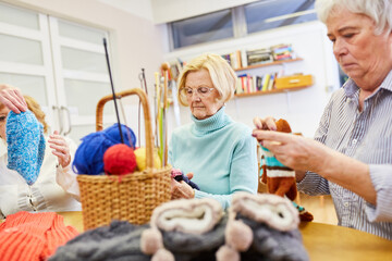 Seniors crocheting together in handicraft course