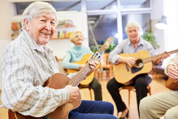 Senior man plays guitar in a guitar class