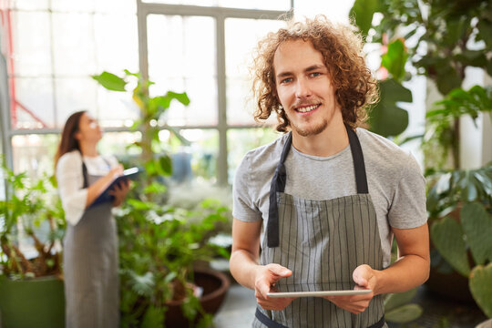 Florist with checklist at inventory in flower shop