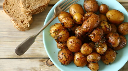 Selective focus. Macro. Fried potatoes in their skins on a plate. Rustic potatoes.