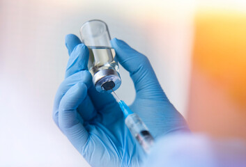 doctor is holding syringe and vaccine for vaccination