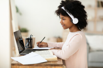 Black Teen Girl At Laptop Doing Homework Online At Home