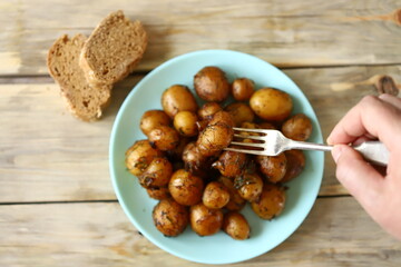 Selective focus. Macro. Fried potatoes in their skins on a plate. Rustic potatoes.