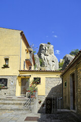 A small road crosses the old buildings of Catelmezzano, a rural village in the Basilicata region, Italy.
