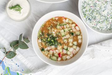 Summer cold soup okroshka with egg, radish, cucumber and dill served on the table