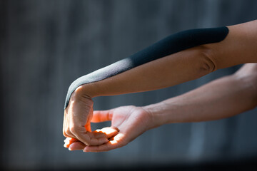 Women's hands with a plaster glued from the elbow to the wrist for kinesitherapy and rehabilitation...