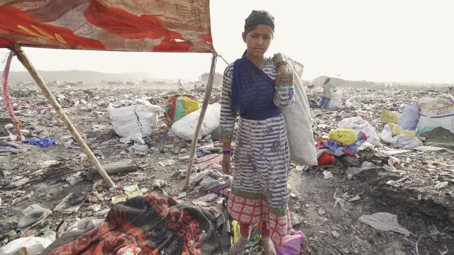Young people working on landfill site recycling plastics and cardboard. India.
