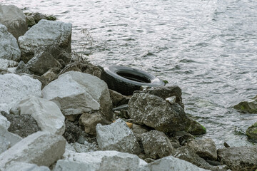 Used car tires remained in nature. The old unnecessary tire of car remained in the water. The...