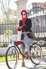 Beautiful carefree woman riding a bike in the street 