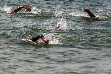 Swimmer swims in sea. Athlete triathlete swimmer drains from water. A professional athlete in...