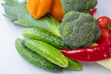 Fresh green vegetables on a white background. Broccoli, cucumbers close-up.