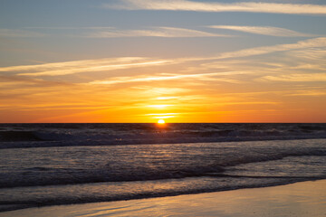Obraz premium Sunset in the long beach of Zahara de los Atunes marking the horizon line in the Atlantic Ocean, Cadiz, Spain