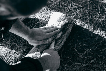 A man with a knife cuts fish in forest