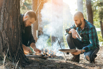 Two mans with a knife cuts fish in forest