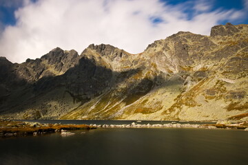 A mountain lake under the moutnains on a cloudy autumn day