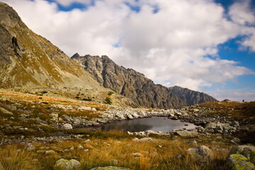 Fototapeta na wymiar A small mountain lake surrounded by rocks in autumn