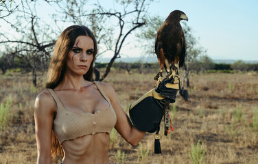 Beautiful woman posing on nature with eagle