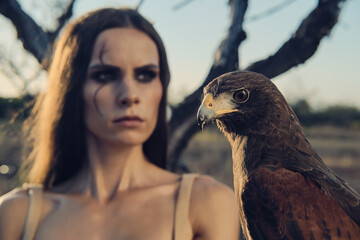Beautiful woman posing on nature with eagle
