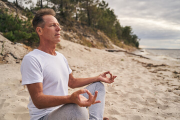 Fototapeta na wymiar Man relaxing during meditation in inhabitant beach